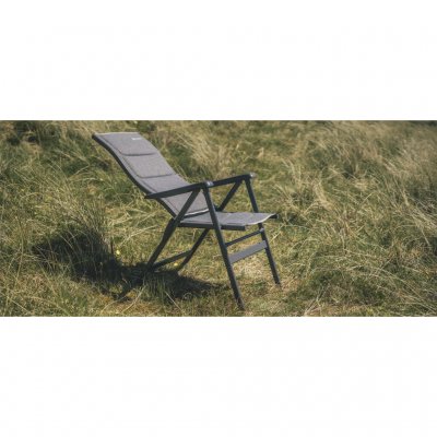 Lehnen Sie sich im Campingstuhl zurück und lesen Sie ein Buch außerhalb des Wohnwagens oder Zeltes.