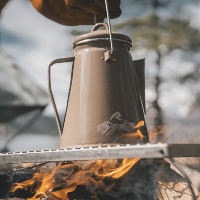 Khakifarbener Emaille-Kessel von Robens mit Bügel zum Aufhängen an einem Haken über dem Feuer.